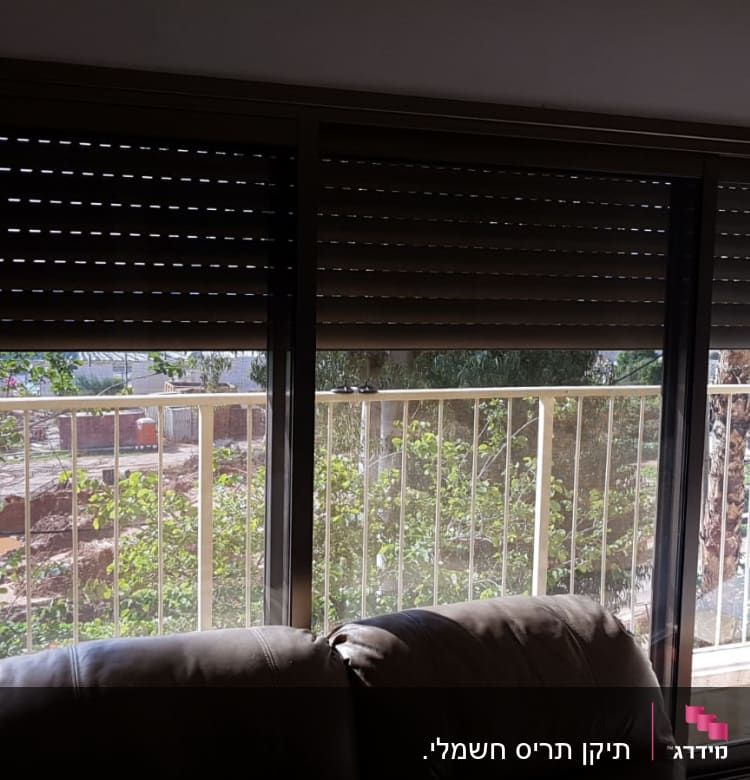 תריסים חומים סגורים על חלון זכוכית גדול